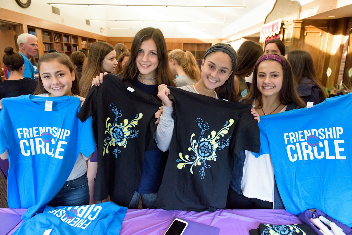 Volunteers holding Friendship Circle shirts